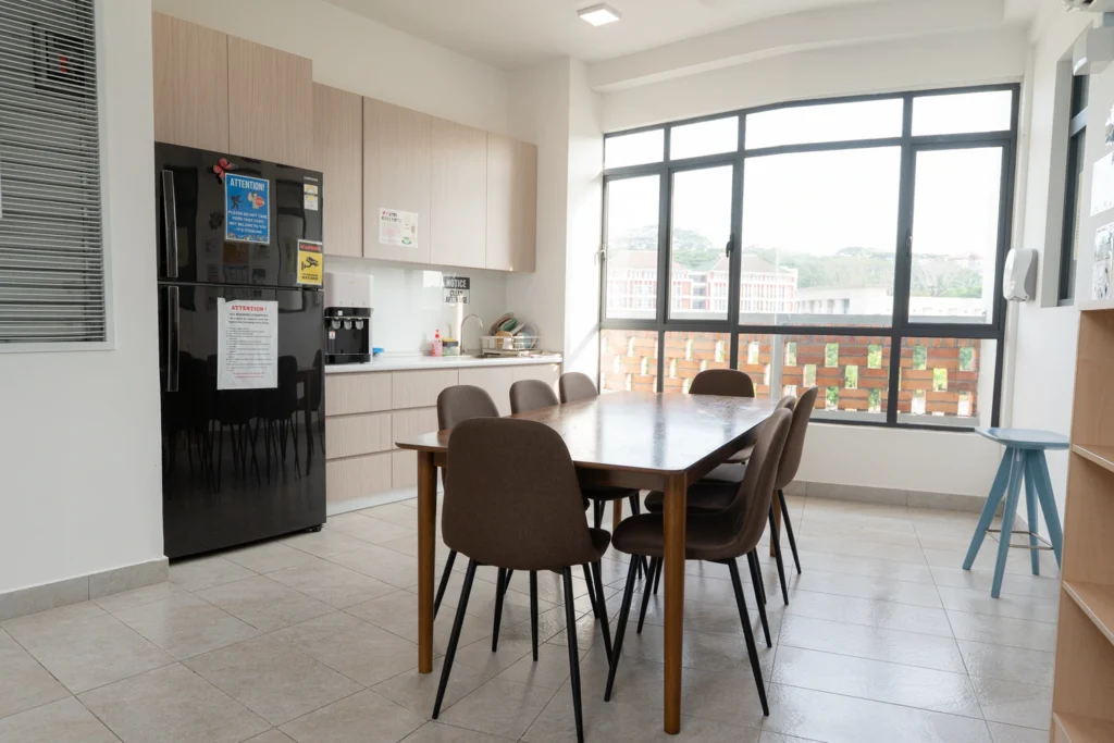 The shared dining table and kitchenette with a view over the campus.