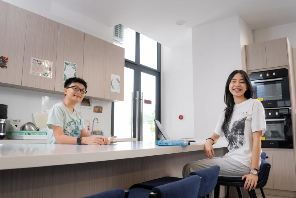 Boarders chat at the kitchen counter of the boarding house.