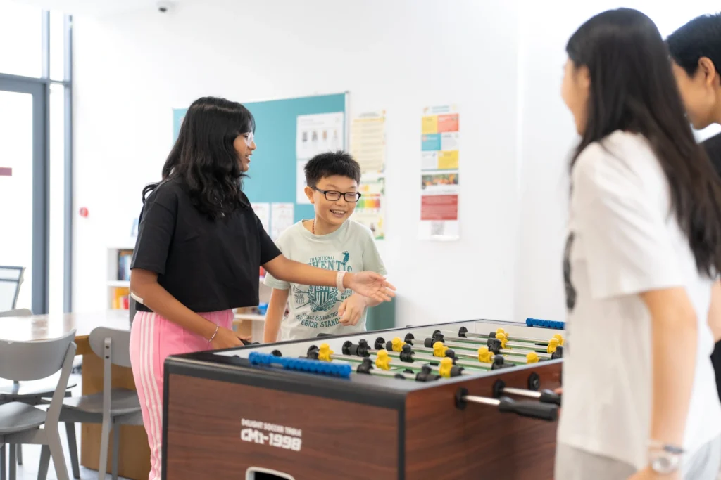 Boarders play table football together.
