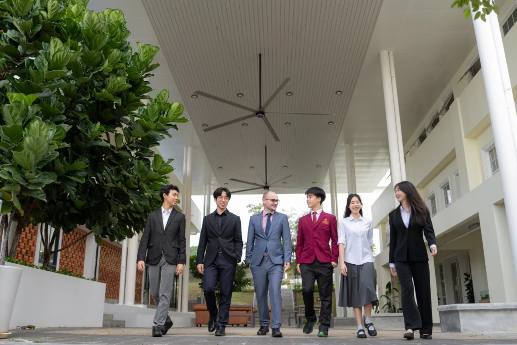 A teacher walks with students through the campus.