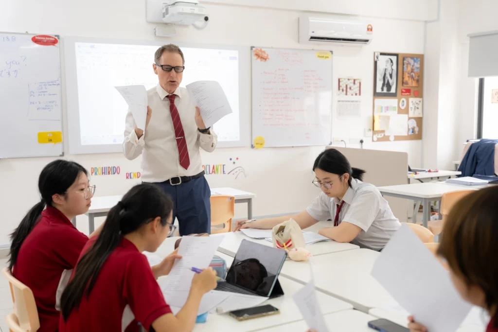 A teacher leads a Japanese club session for a group of students.