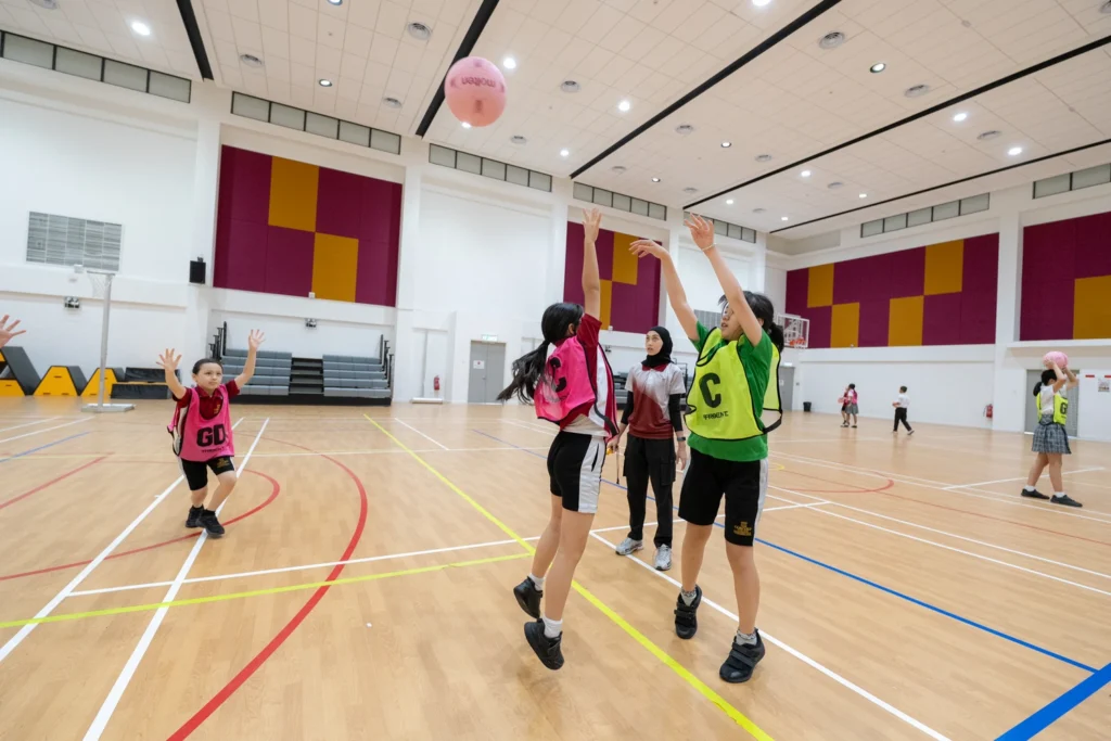 A student leaps to catch the ball during netball.