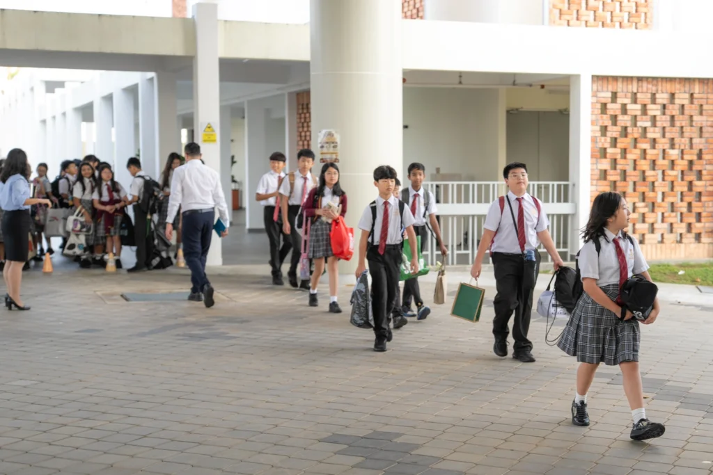 Staff walk students to the school entrance.