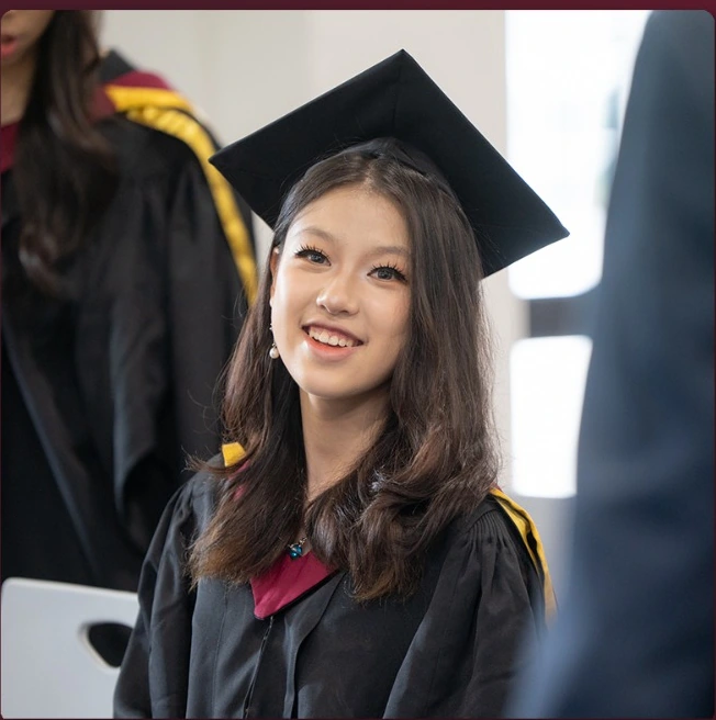A Concord College International School graduate in cap and gown on graduation day.