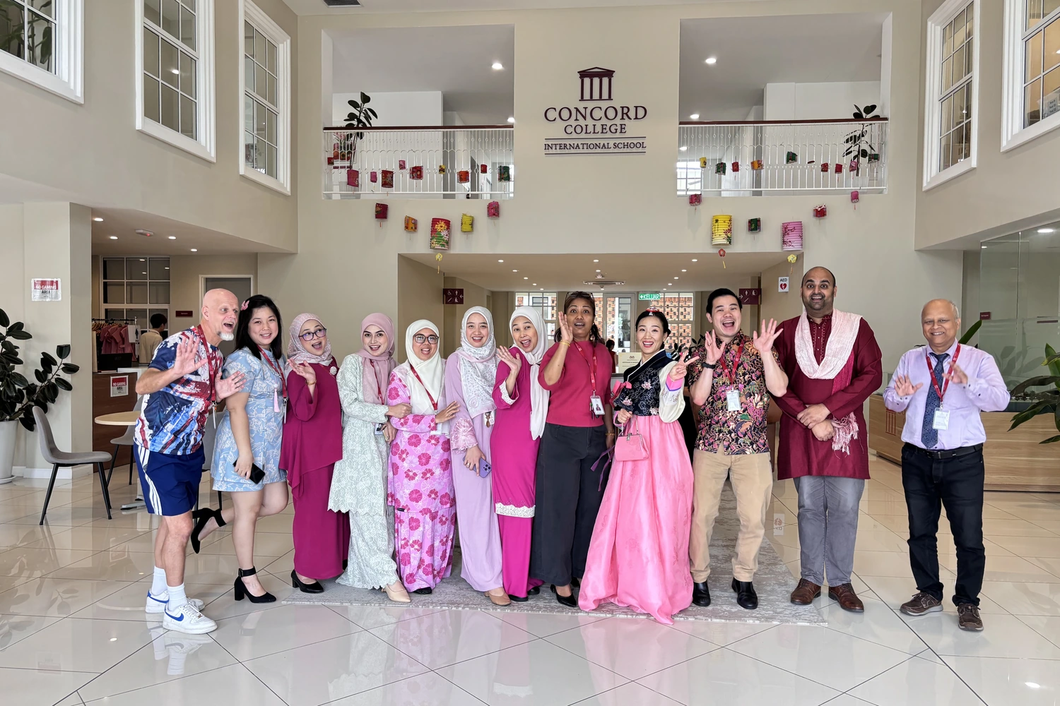 Staff gathered in the school foyer in cultural dress for a celebration day.