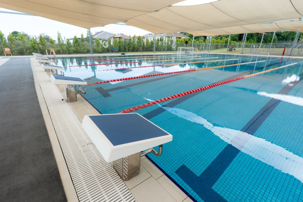 The outdoor swimming pool with lane ropes and starting blocks.