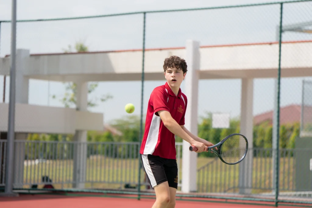Students playing tennis on the school courts.